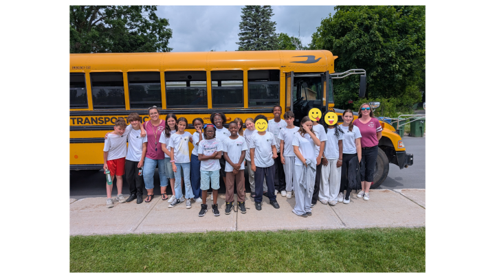 Groupe d'élèves devant un autobus scolaire.